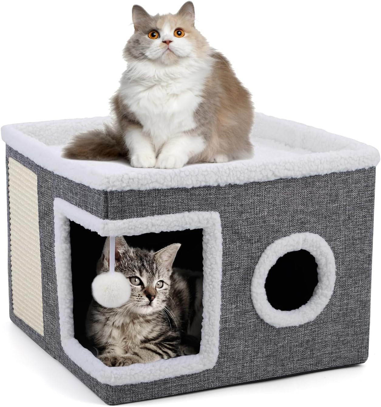 Chat couché à l’intérieur d’un cube gris pliable pour chat, avec pompon suspendu à l’entrée.